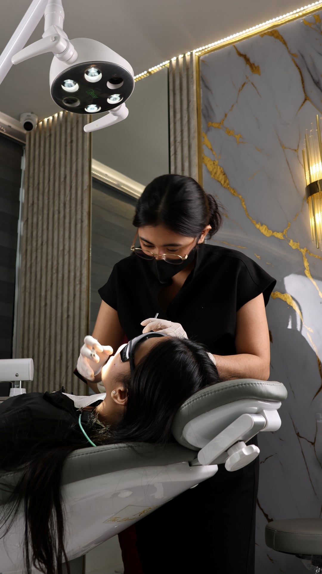 Woman receiving a cosmetic procedure in a professional setting with marble walls.